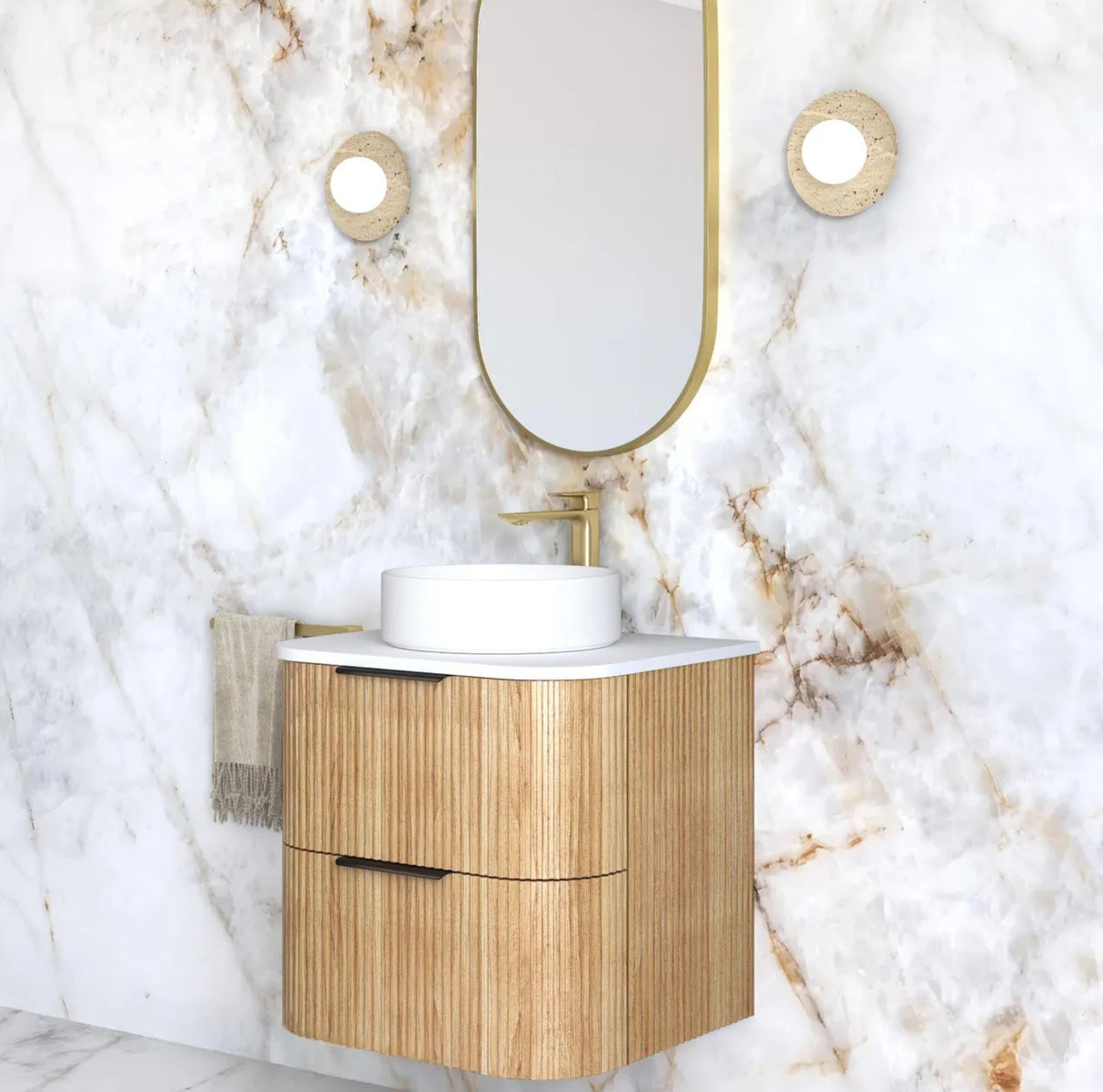 Bathroom vanity with wooden cabinet and white countertop against a marble wall.