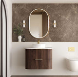 Modern bathroom with wooden vanity, round mirror, and decorative elements.