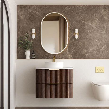 Modern bathroom with wooden vanity, round mirror, and decorative elements.