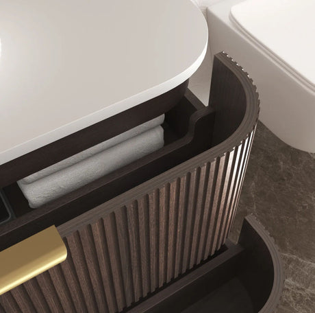 Bathroom vanity with open cabinet revealing folded towels, set against a neutral bathroom background.