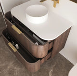 Bathroom vanity with white countertop, brown cabinet, and gold fixtures.