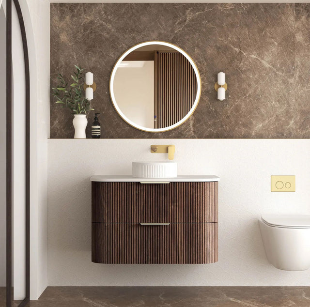 Modern bathroom with wooden vanity, round mirror, and decorative elements.
