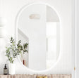 Round mirror on a white wall with decorative elements