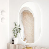 Modern bathroom interior with a mirror, plant, and decorative items.