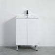 White bathroom vanity with sink and faucet against a plain wall.