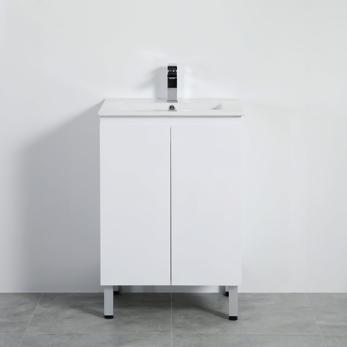 White bathroom vanity with sink and faucet against a plain wall.