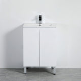 White bathroom vanity with sink and faucet against a plain wall.