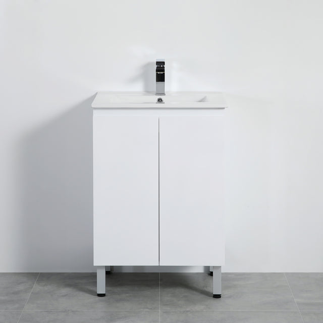 White bathroom vanity with sink and faucet against a plain wall.