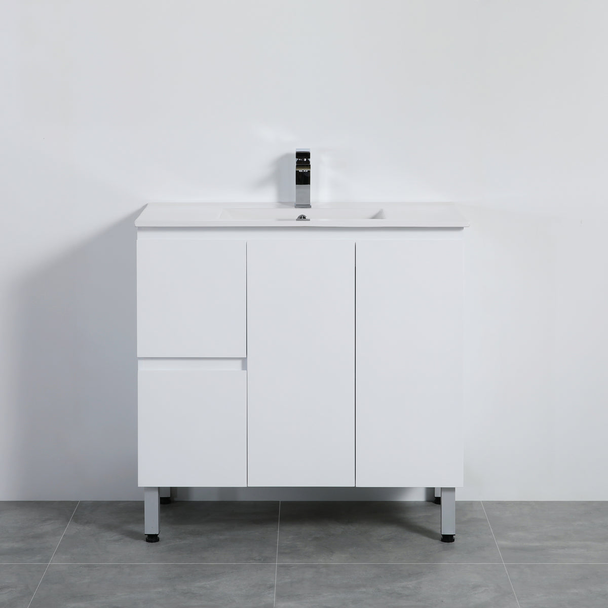 White bathroom vanity with a sink on a gray floor against a white wall