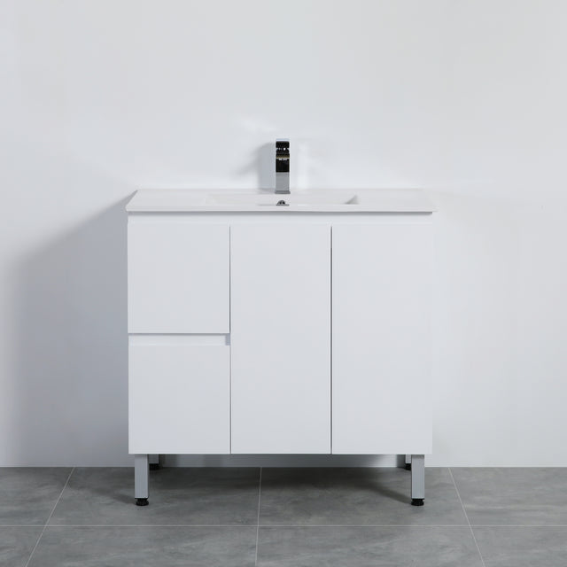 White bathroom vanity with a sink on a gray floor against a white wall