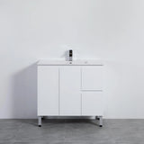White bathroom vanity with sink against a plain white wall.