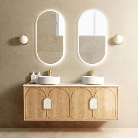 Bathroom vanity with two round sinks, wooden cabinet, and illuminated mirrors.