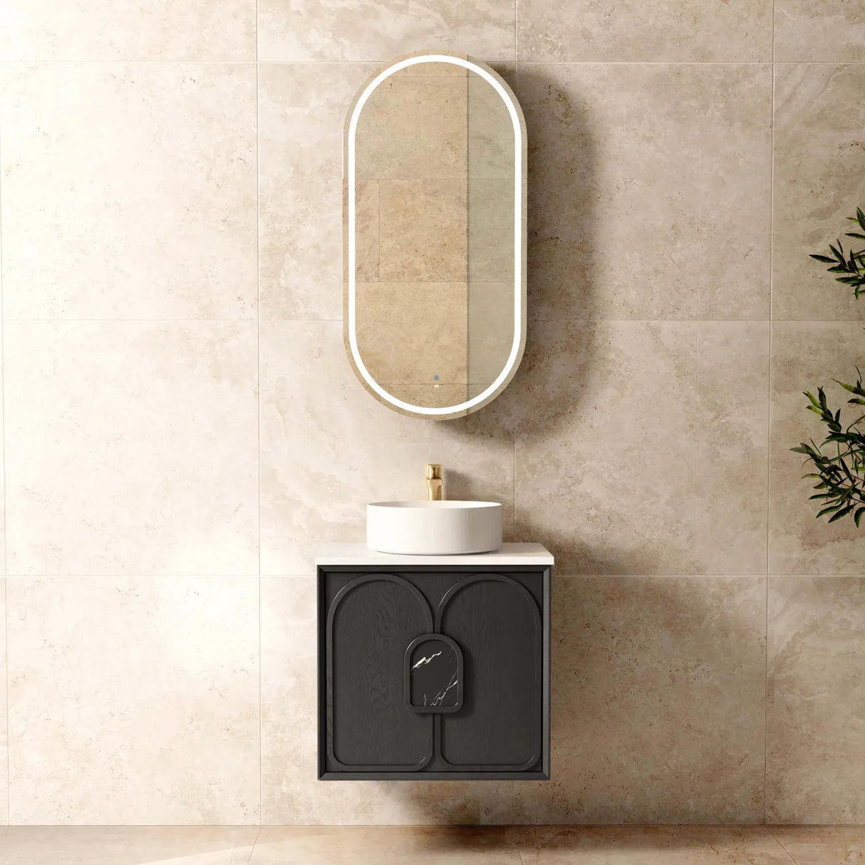 Bathroom setup with a black vanity, white sink, and oval mirror on a beige tiled wall.