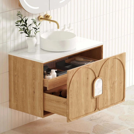 Bathroom vanity with open drawer, sink, and decorative elements.