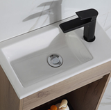 White sink with a black faucet on a wooden vanity