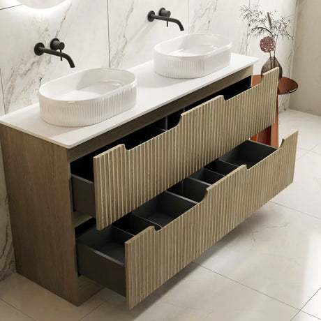Bathroom vanity with two white sinks and multiple drawers in a modern bathroom setting.