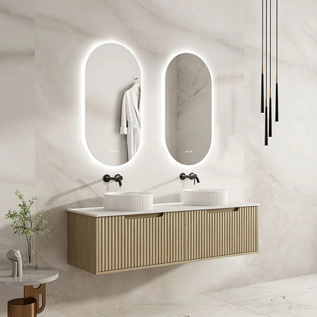 Modern bathroom with double vanity, illuminated mirrors, and decorative elements.
