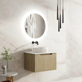 Modern bathroom with a wall-mounted vanity, round mirror, and decorative elements.