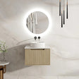 Modern bathroom with a round mirror, sink, and wooden cabinet.