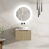 Modern bathroom with a round mirror, sink, and wooden cabinet.