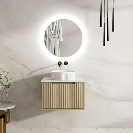 Modern bathroom with a round mirror, sink, and wooden cabinet.