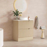 Bathroom vanity with mirror and light fixture against a marble wall.