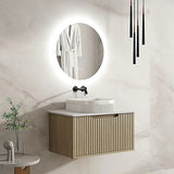 Modern bathroom with a vanity, round mirror, and decorative elements.
