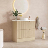 Bathroom vanity with sink, mirror, and decorative items against a beige wall.