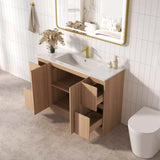 Bathroom with wooden vanity, sink, and toilet against a tiled wall.