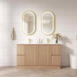 Bathroom vanity with wooden cabinets, white countertop, and two oval mirrors with gold frames.