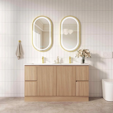 Bathroom vanity with wooden cabinets, white countertop, and two oval mirrors with gold frames.