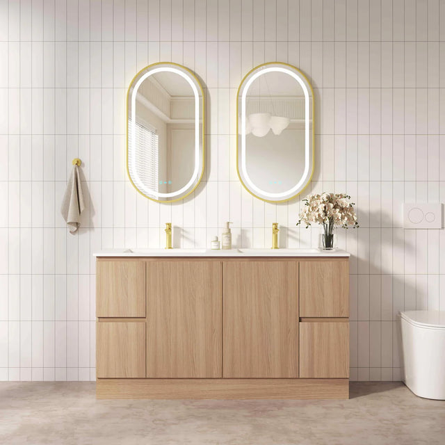 Bathroom vanity with wooden cabinets, white countertop, and two oval mirrors with gold frames.