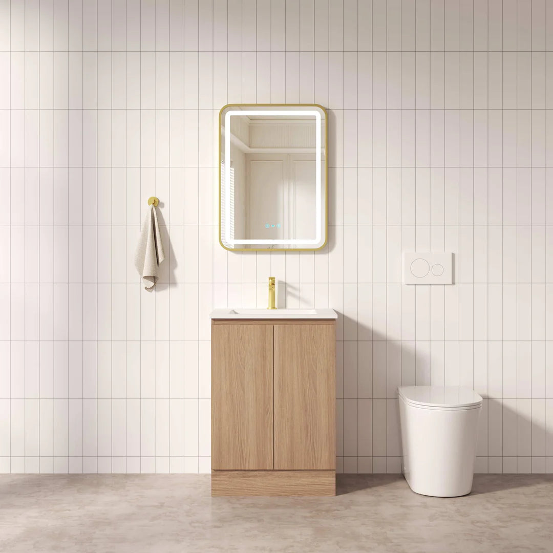 Bathroom with wooden vanity, mirror, and toilet against a tiled wall.