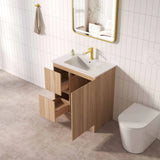 Bathroom with wooden vanity, sink, and toilet against a tiled wall.