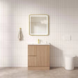 Bathroom with wooden vanity, mirror, and toilet against a tiled wall.