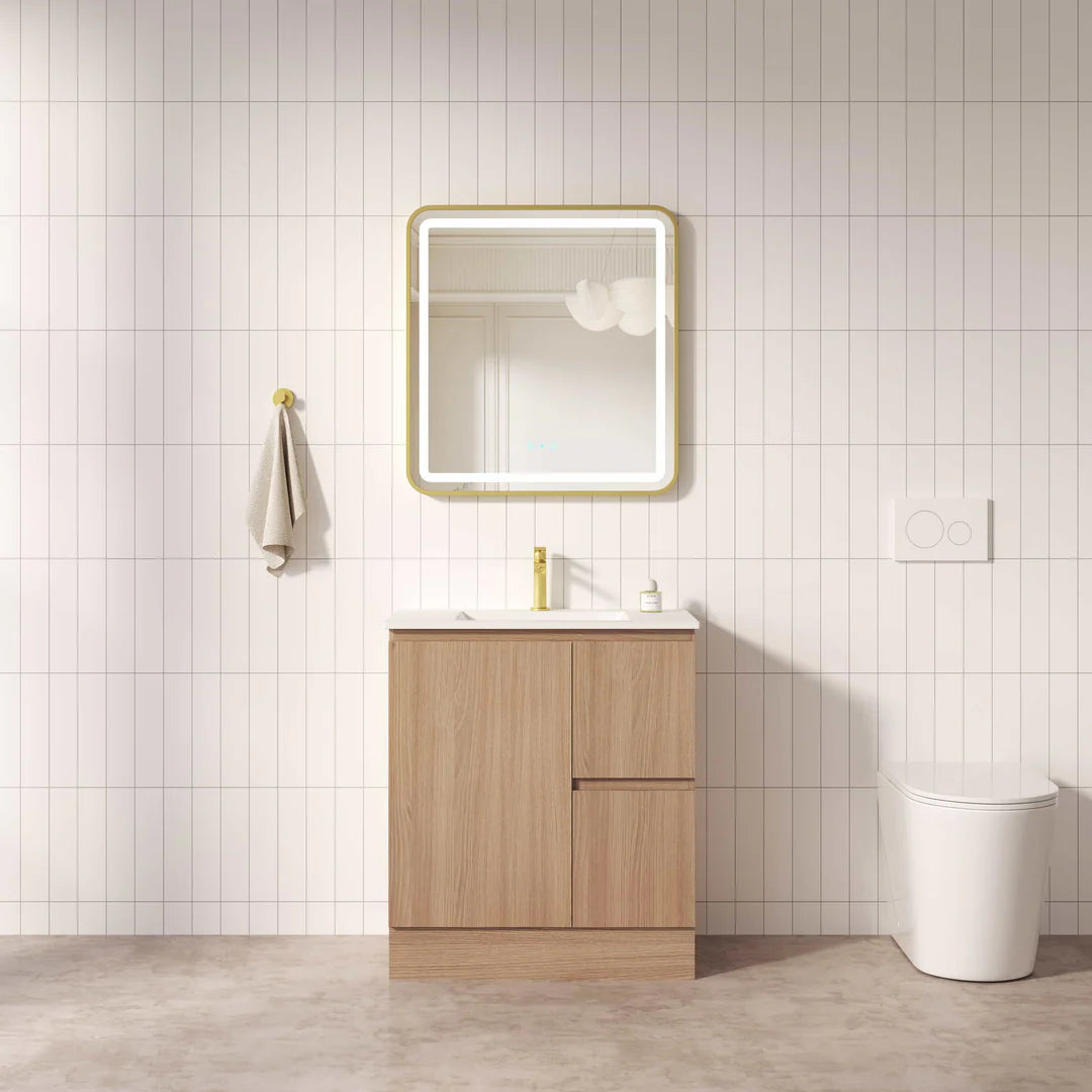 Bathroom with wooden vanity, mirror, and toilet against a tiled wall.