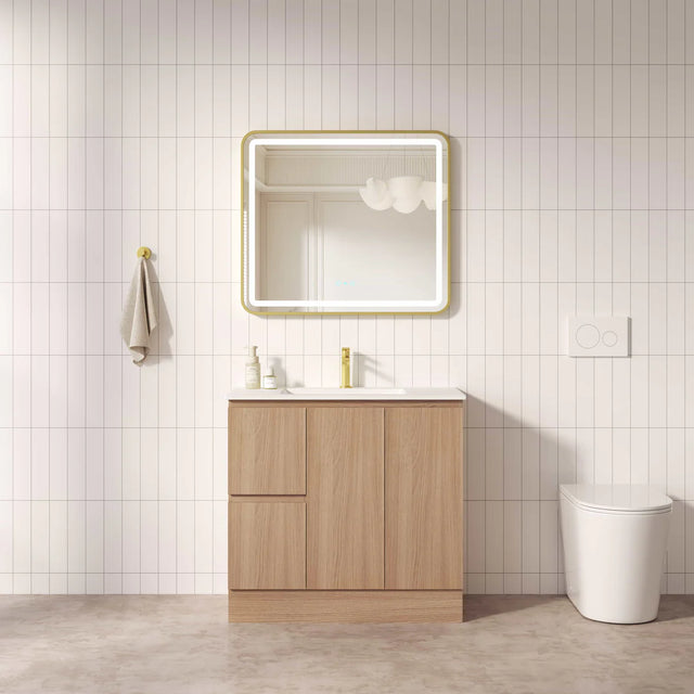Bathroom with wooden vanity, mirror, and toilet against a tiled wall.