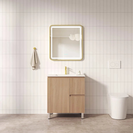 Bathroom with wooden vanity, mirror, and toilet against a tiled wall.