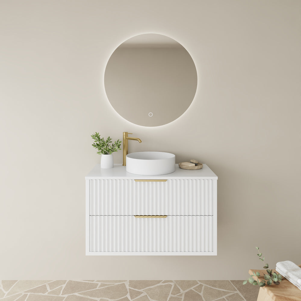 Bathroom vanity with round mirror, sink, and decorative elements on a neutral wall.