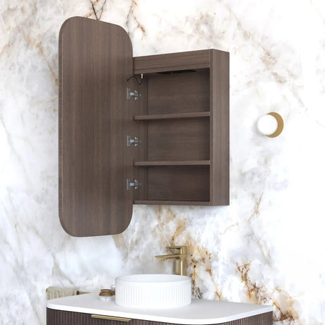 Wooden wall-mounted cabinet with open door against a marble wall.