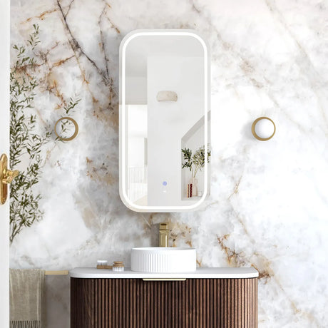 Bathroom vanity with a mirror on a marble wall