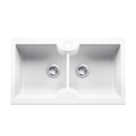A white double-bowl undermount kitchen sink with two chrome drain strainers and a central divider, shown from a top-down perspective on a solid white background.
