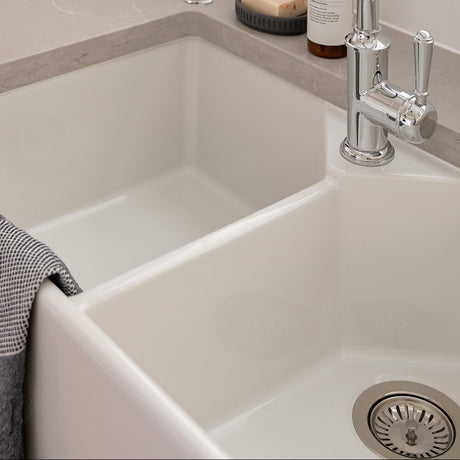 White kitchen sink with silver faucet, soap bottle, and bar of soap.