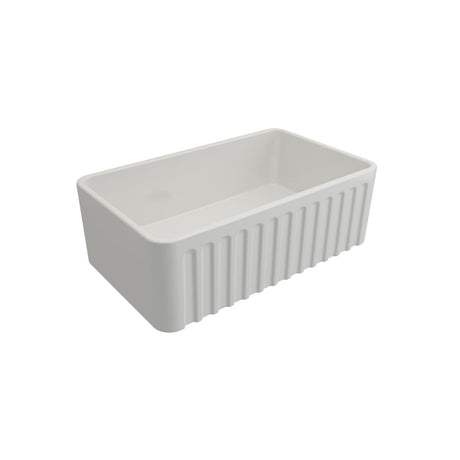 A white rectangular farmhouse sink with a fluted front, shown at an angle on a solid white background.