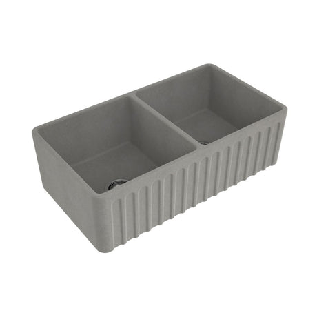 A gray dual-bowl farmhouse sink with a ribbed front apron, shown from an elevated angle on a plain white background.