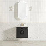 Bathroom with a white freestanding bathtub against a tiled wall and a black vanity unit.
