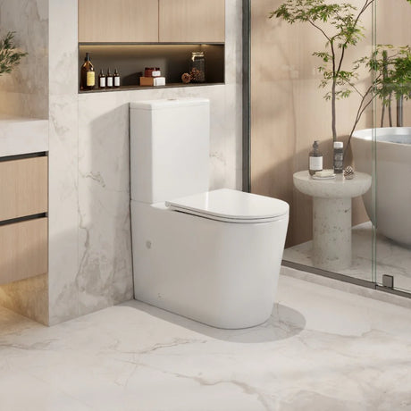 Modern white toilet in a stylish bathroom with marble walls and decor.
