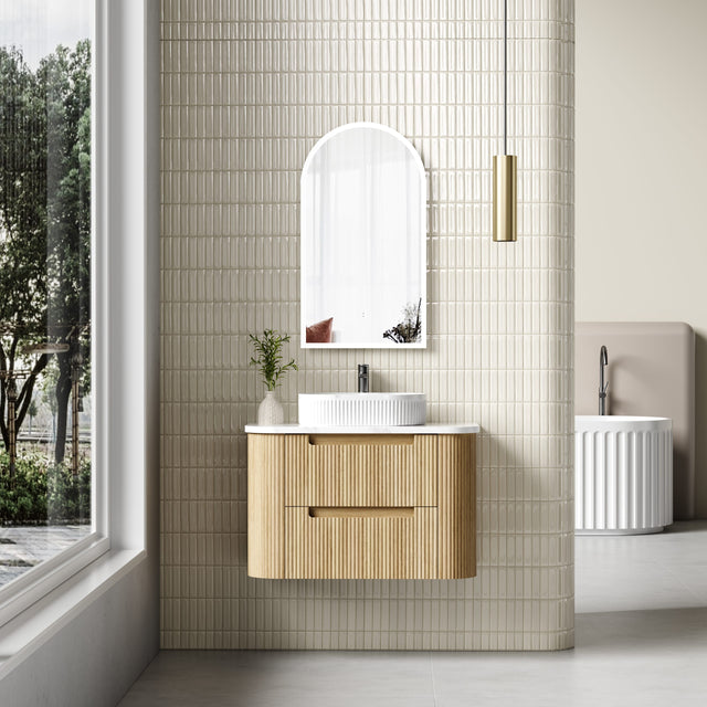 Bathroom with wooden vanity, mirror, and window view