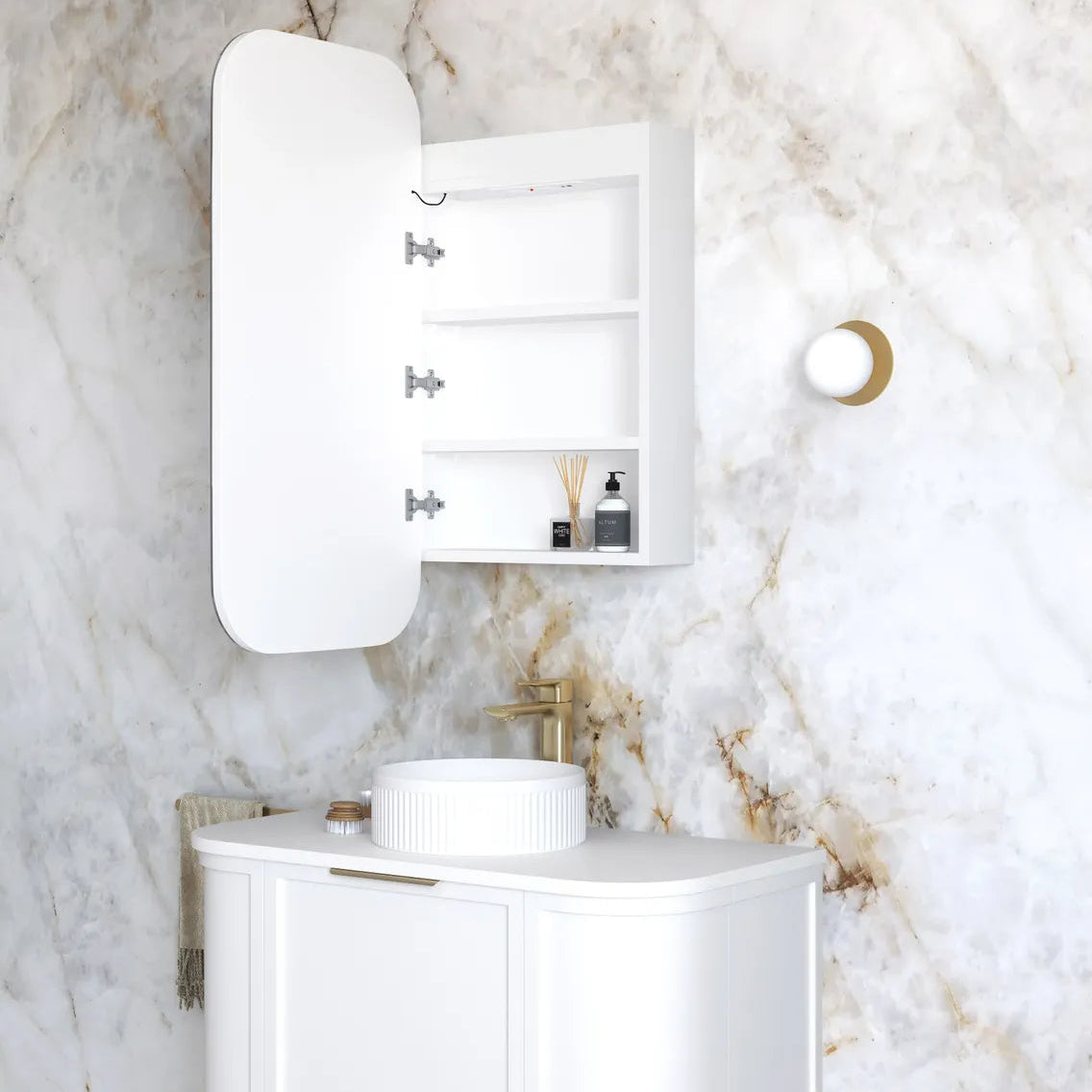 Bathroom with white vanity, sink, and mirror against a marble wall.