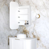 Bathroom with white vanity, sink, and mirror against a marble wall.
